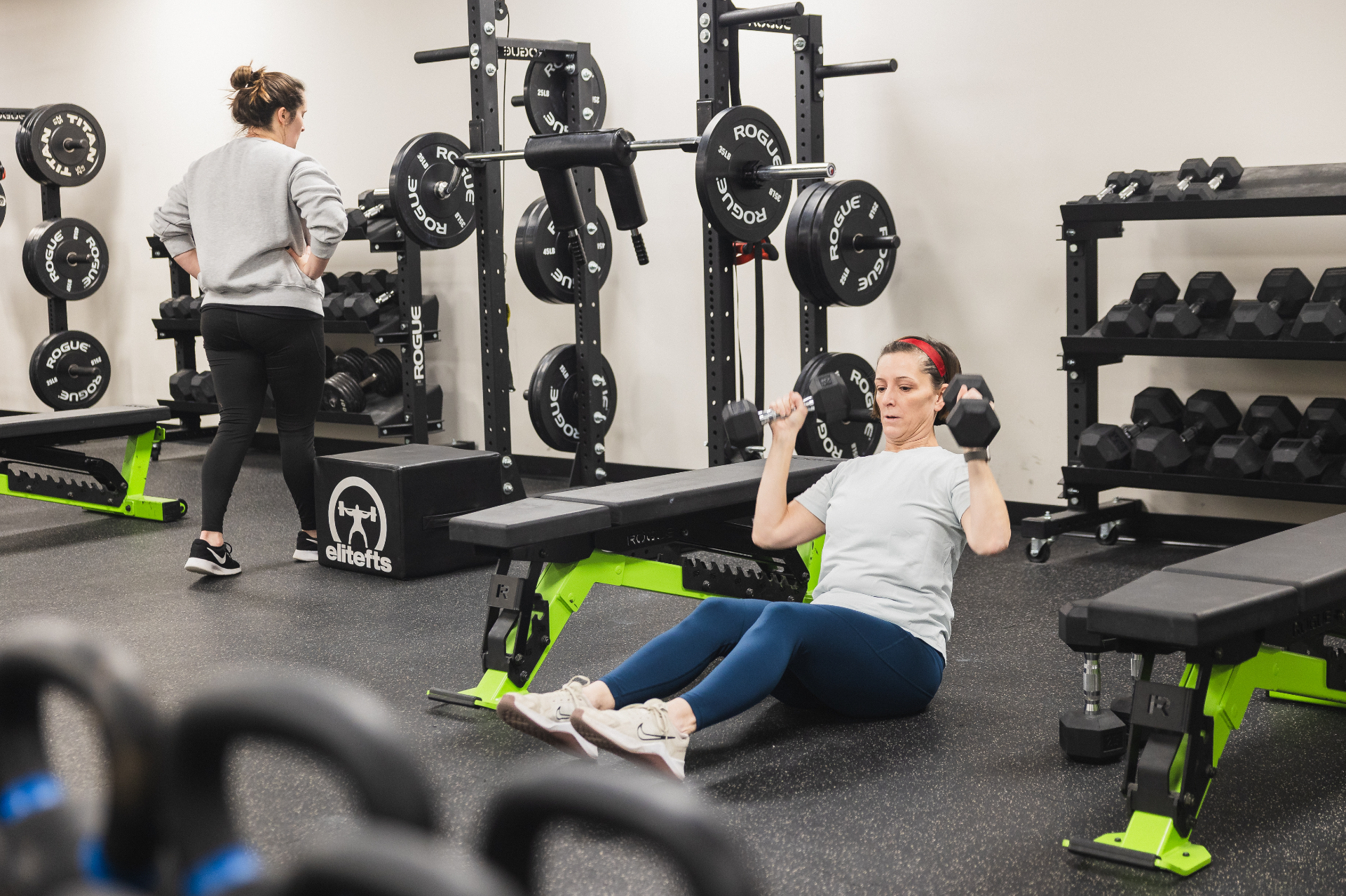 Adult member doing dumbbell sit-ups in the gym