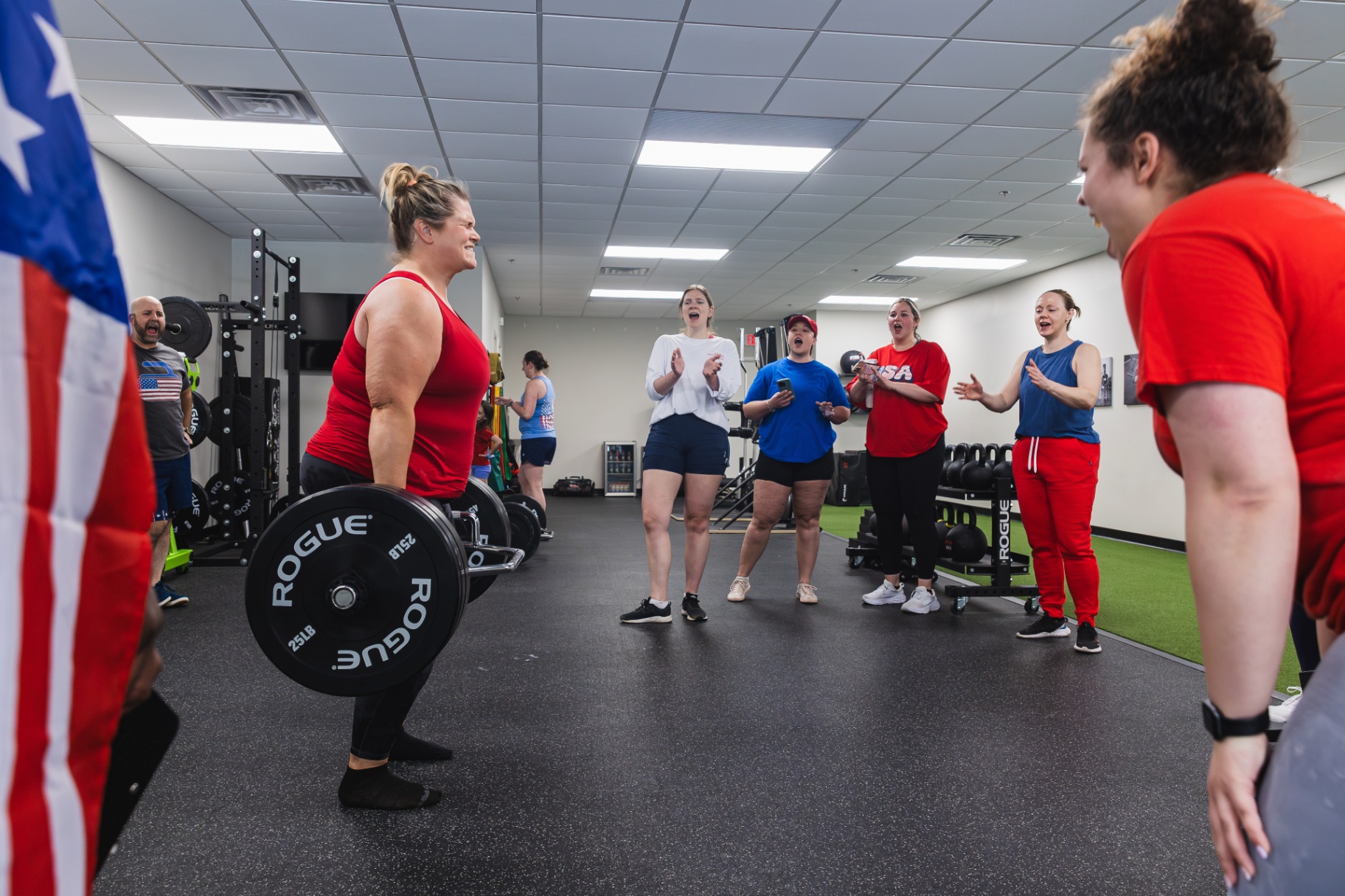 Group of adults cheering on a teammate's deadlift